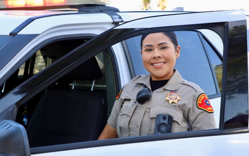A Kern County Sheriff's Deputy Standing Next to Patrol Car